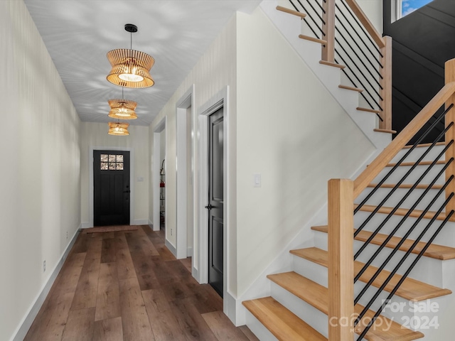 entryway with hardwood / wood-style flooring and a notable chandelier