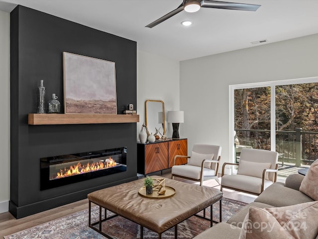 living room featuring light wood-type flooring, plenty of natural light, and ceiling fan