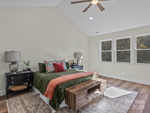 bedroom with hardwood / wood-style floors, high vaulted ceiling, and ceiling fan