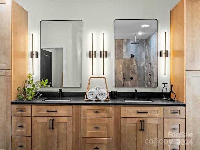 bathroom with vanity and a tile shower