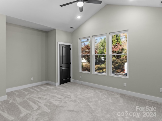 carpeted empty room featuring vaulted ceiling and ceiling fan