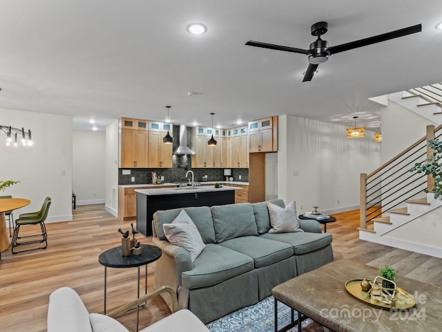 living room featuring ceiling fan, light hardwood / wood-style flooring, and sink