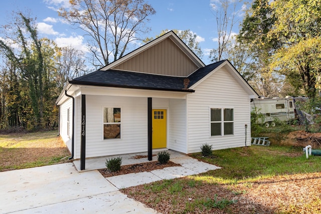 view of front of home with covered porch and a front lawn