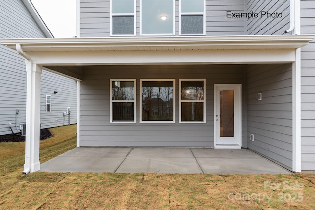 view of exterior entry featuring a yard and a patio