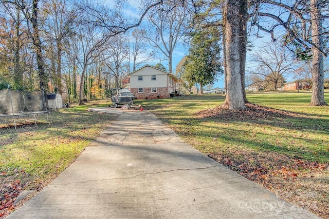 view of front of house with a front yard and a trampoline