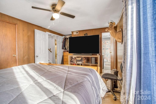 bedroom featuring ceiling fan and wooden walls