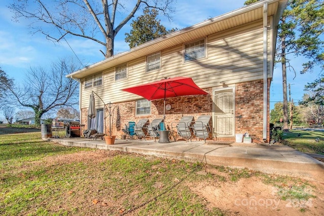 back of house featuring a lawn and a patio