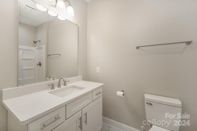 bathroom featuring vanity, toilet, and walk in shower