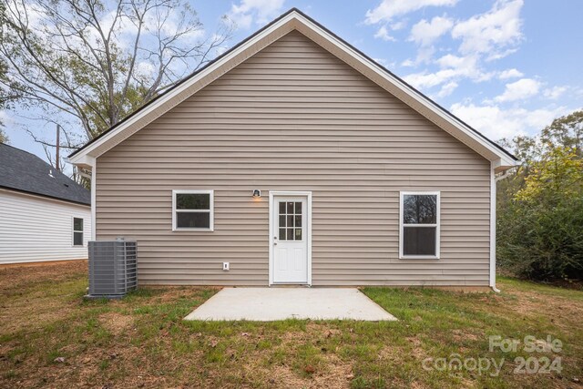 rear view of house featuring central AC, a patio area, and a lawn