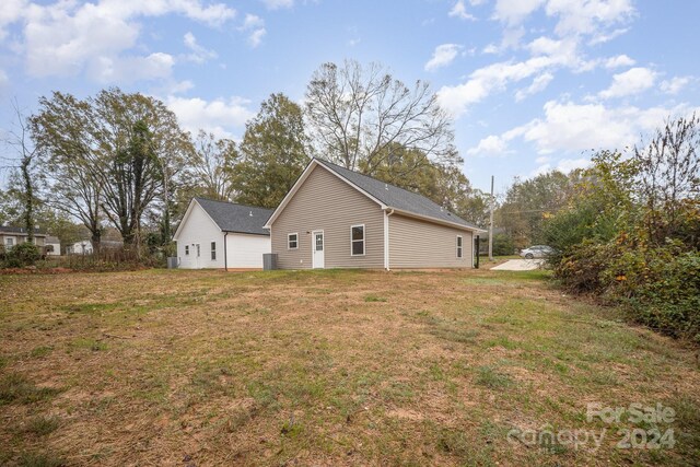 rear view of house featuring a yard