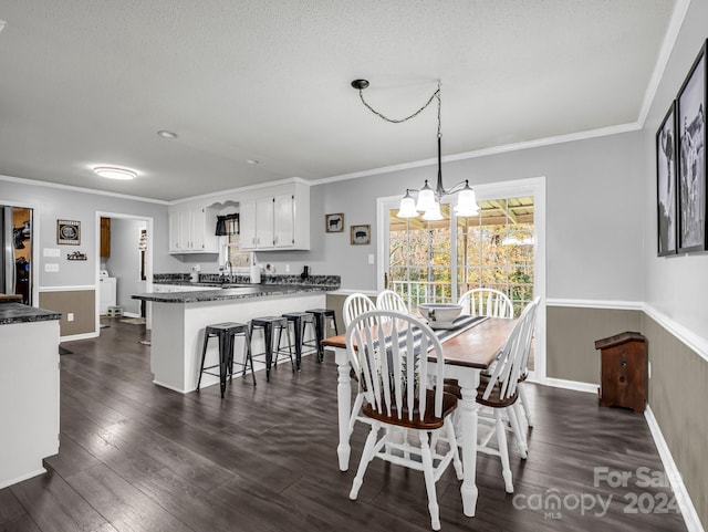 dining area with dark hardwood / wood-style flooring, a textured ceiling, and a chandelier