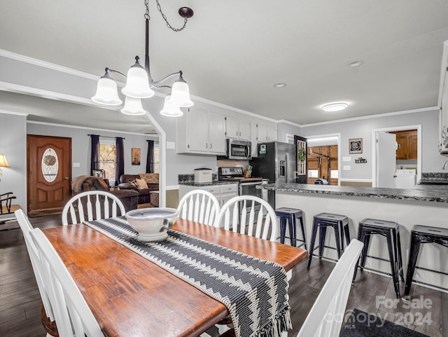 dining space featuring crown molding, dark hardwood / wood-style flooring, and a notable chandelier