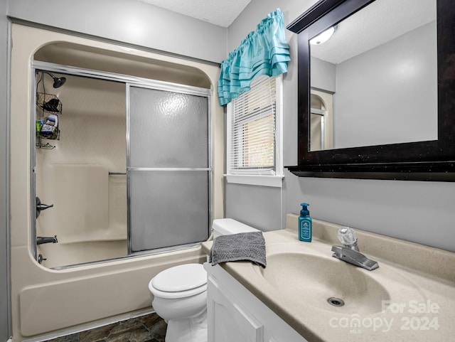 full bathroom with vanity, toilet, shower / bath combination with glass door, and a textured ceiling