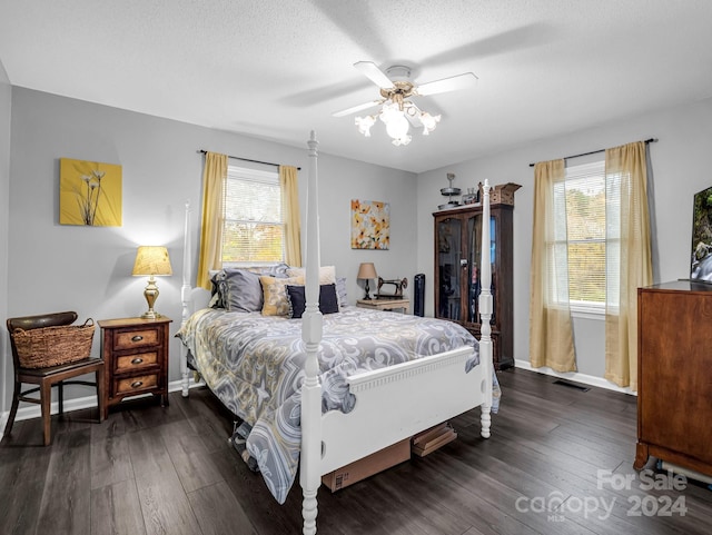 bedroom with ceiling fan, dark hardwood / wood-style flooring, and a textured ceiling