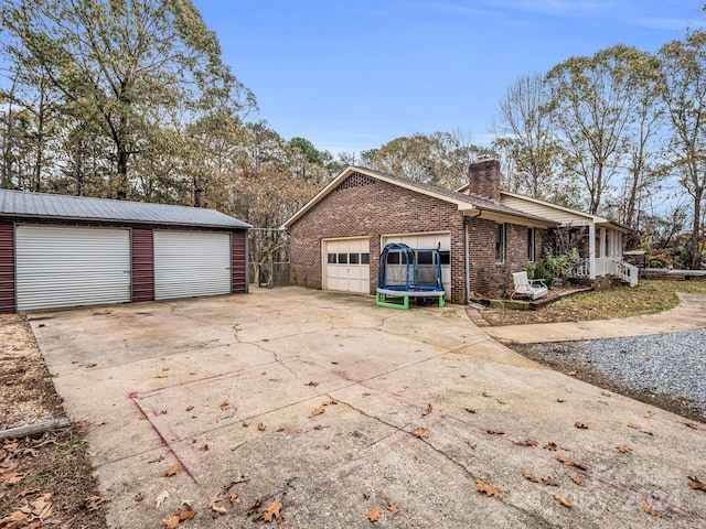 view of side of property with a garage and an outbuilding