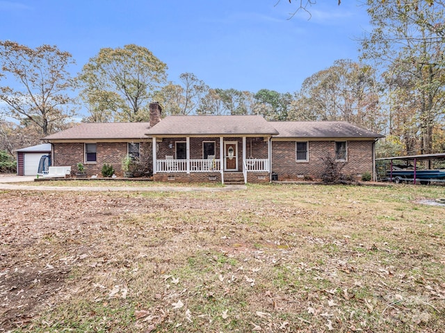 single story home with a garage, covered porch, an outbuilding, and a front lawn