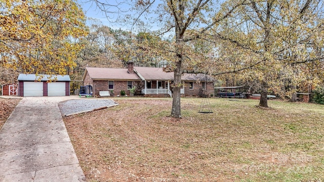 ranch-style home with covered porch, a garage, a front lawn, and an outdoor structure