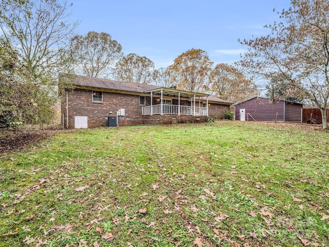 back of house featuring a yard and central air condition unit