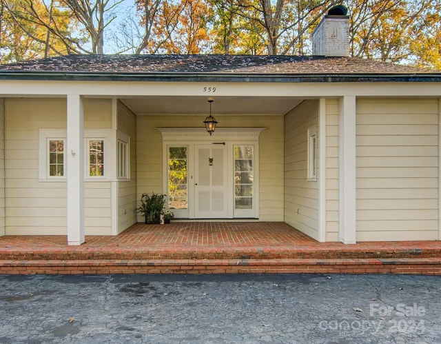 view of exterior entry featuring covered porch