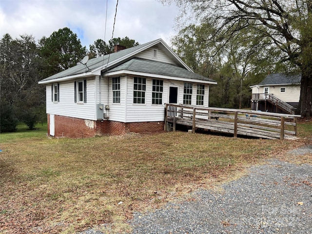 view of front facade featuring a front yard and a wooden deck