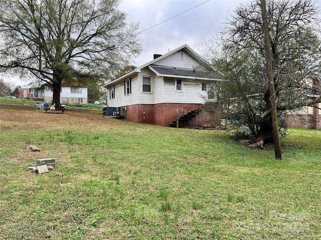 210 Lincoln St, Albemarle, NC 28001 - view of property exterior with central AC, a lawn, stairway, and a chimney