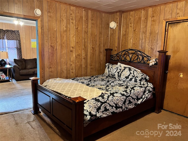 carpeted bedroom featuring wood walls