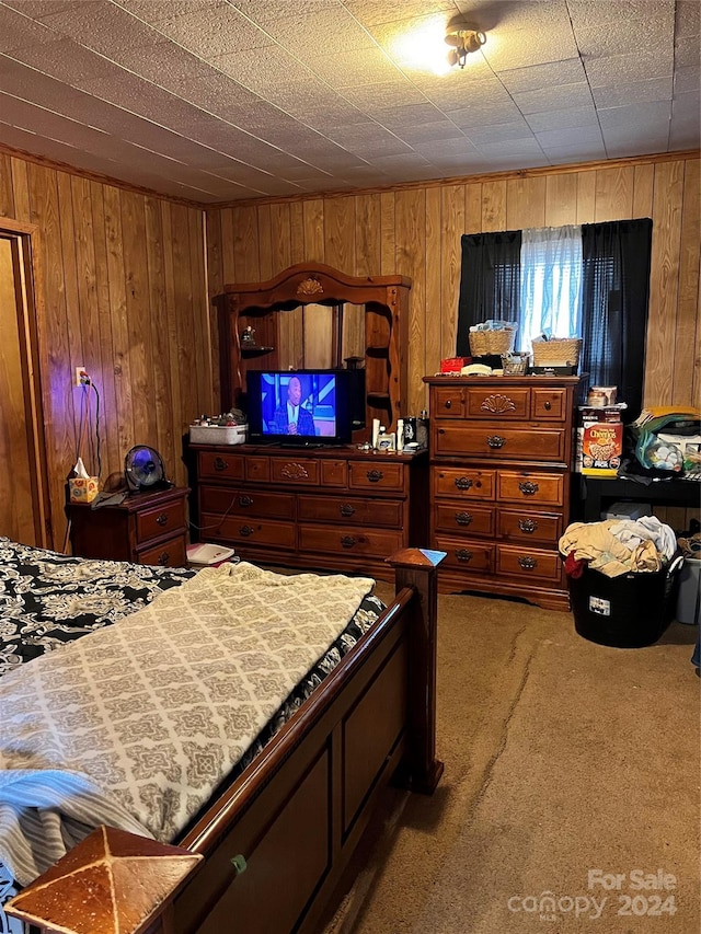 carpeted bedroom featuring wood walls