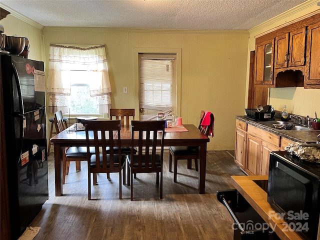 dining area with crown molding, dark wood-type flooring, a textured ceiling, and sink