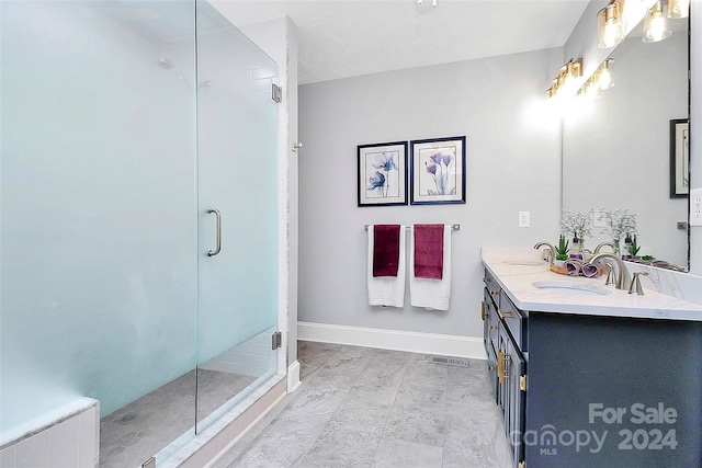 bathroom with a textured ceiling, vanity, and an enclosed shower