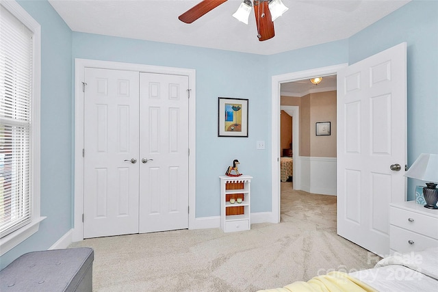 carpeted bedroom featuring a closet and ceiling fan