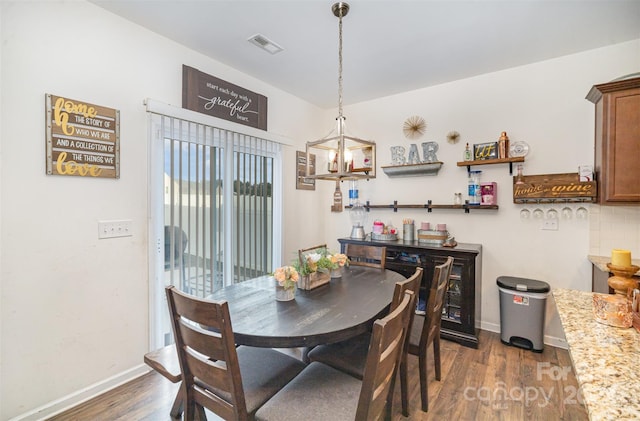 dining space featuring a chandelier and dark hardwood / wood-style flooring