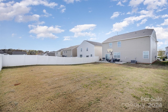 rear view of house with a yard, a patio, and central AC