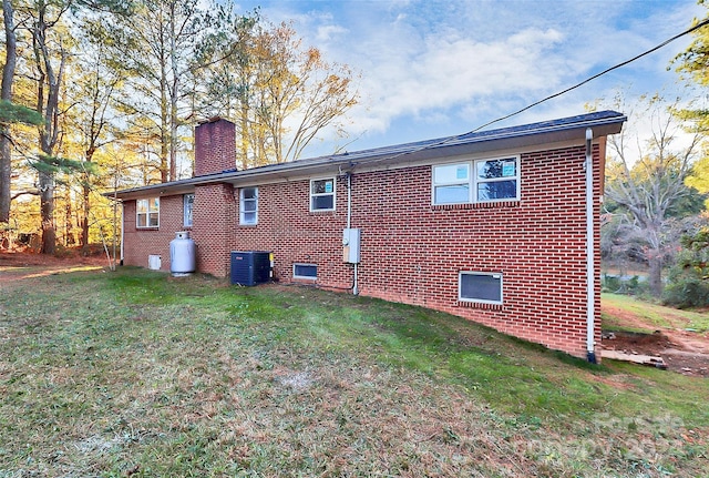 rear view of house featuring a yard and cooling unit