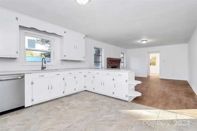 kitchen featuring kitchen peninsula, stainless steel dishwasher, sink, light hardwood / wood-style flooring, and white cabinetry