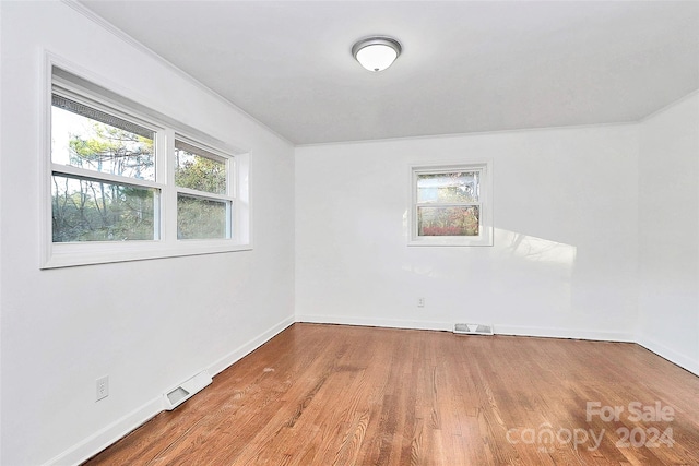 unfurnished room with hardwood / wood-style floors and a healthy amount of sunlight