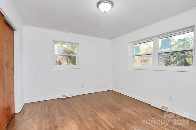 unfurnished room featuring hardwood / wood-style flooring and a wealth of natural light