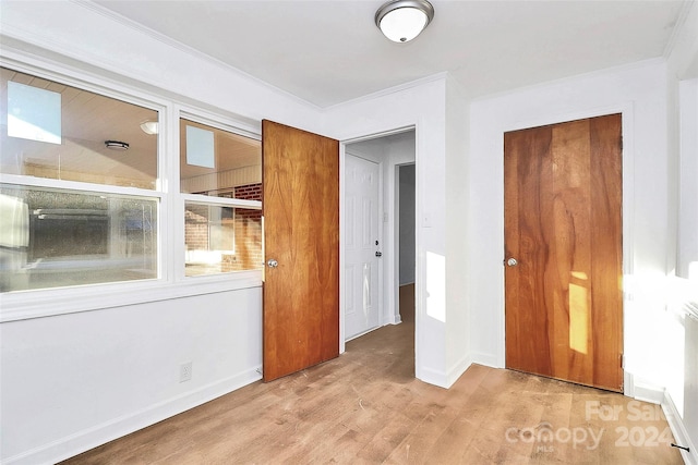 interior space featuring crown molding and light hardwood / wood-style floors