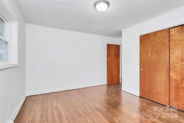 unfurnished bedroom with wood-type flooring and a closet