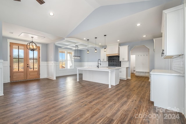 kitchen featuring white cabinetry, tasteful backsplash, an island with sink, pendant lighting, and dark hardwood / wood-style flooring