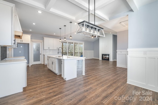 kitchen featuring an island with sink, dark hardwood / wood-style floors, and white cabinetry