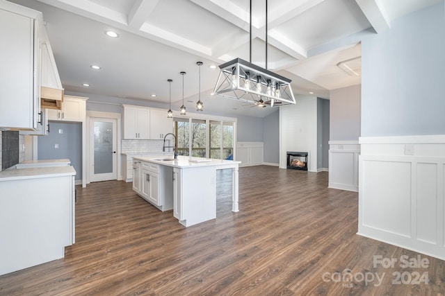 kitchen featuring white cabinets, dark hardwood / wood-style floors, and a kitchen island with sink