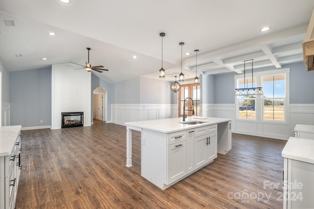 kitchen featuring sink, a kitchen island with sink, dark hardwood / wood-style floors, white cabinetry, and decorative light fixtures