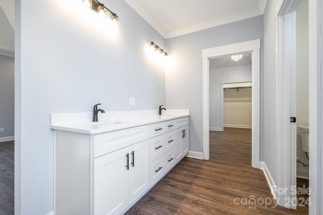 bathroom featuring toilet, vanity, wood-type flooring, and ornamental molding