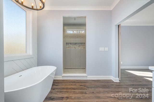 bathroom featuring a wealth of natural light, a bath, hardwood / wood-style flooring, and crown molding