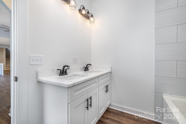 bathroom featuring hardwood / wood-style floors, vanity, and a tub to relax in