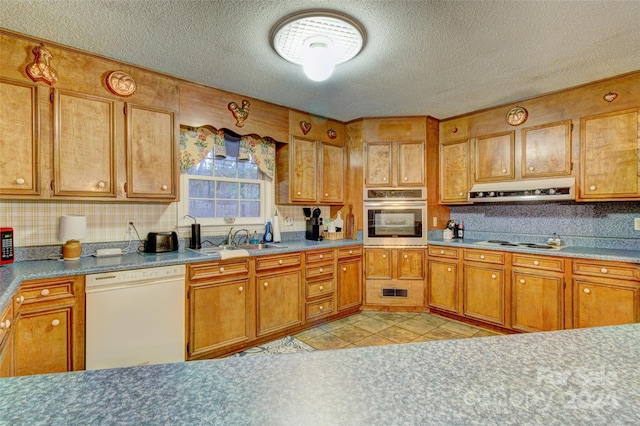 kitchen featuring ventilation hood, a textured ceiling, light tile patterned floors, sink, and white appliances