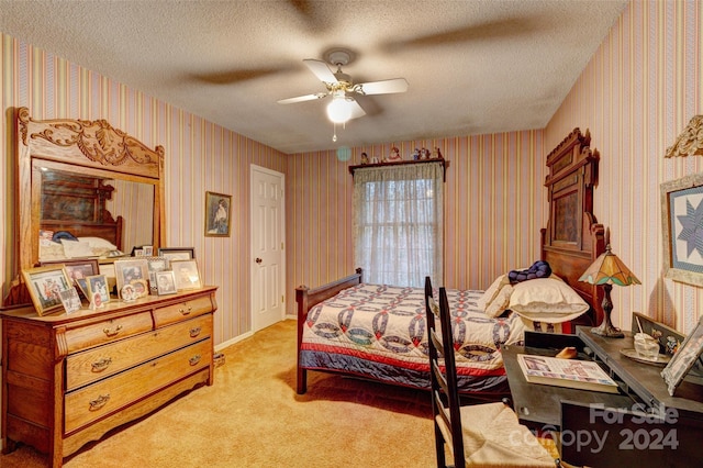 bedroom with a textured ceiling, light colored carpet, and ceiling fan