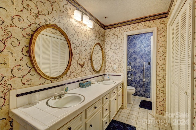 bathroom featuring tile patterned floors, ornamental molding, vanity, a textured ceiling, and toilet