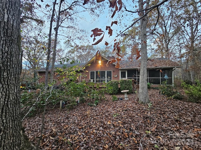 rear view of property featuring a sunroom