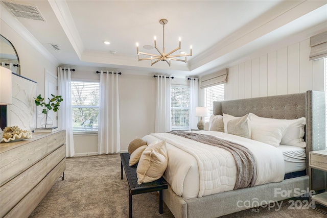 bedroom featuring a tray ceiling, an inviting chandelier, multiple windows, and carpet